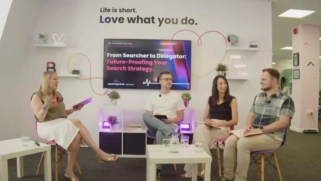Yordan Dimitrov with three other panellists seated in front of a screen showing the title "From Searcher to Delegator", while one of them speaks